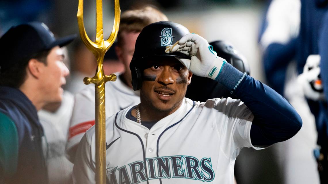 Jorge Polanco holds the trident high as he walks through the dugout.